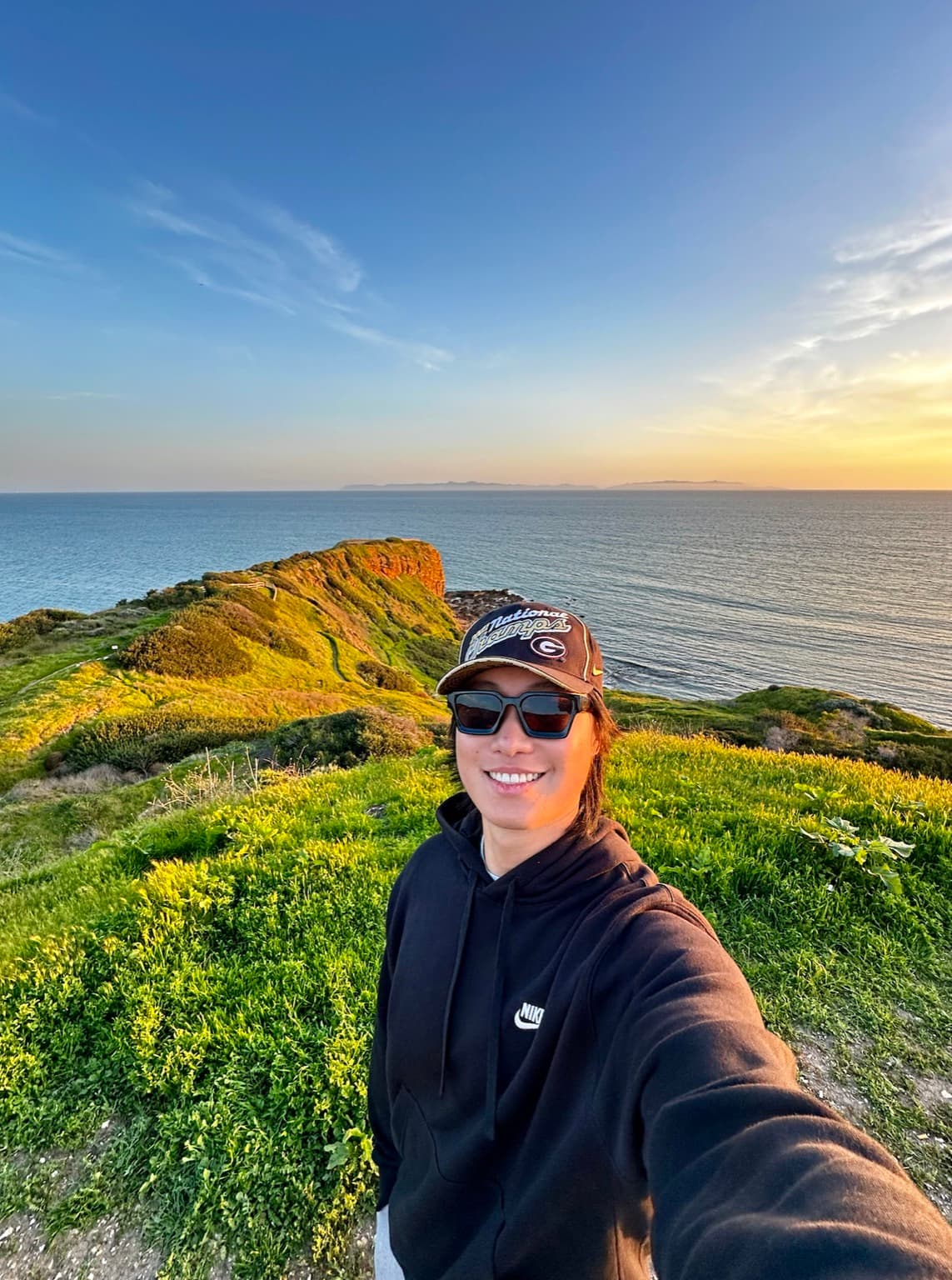 Ruixing Zhang on a coastal hiking trail at sunset
